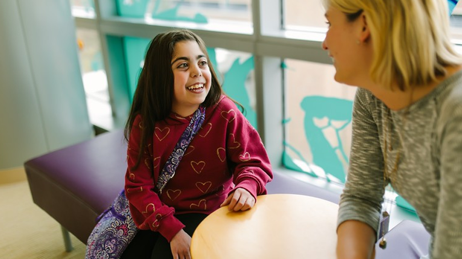 Young girl laughing with a care provider