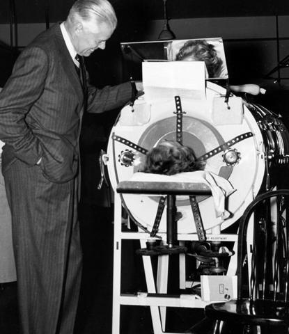 U-M president Harlan Hatcher with an iron lung patient